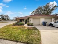 Charming home featuring a red tile roof, well-maintained landscaping, and an attached two-car garage at 18315 Aintree Ct, Tampa, FL 33647