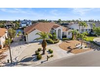 Beautiful house with a well manicured lawn, palm trees, and circular driveway at 818 Golf Island Dr, Apollo Beach, FL 33572