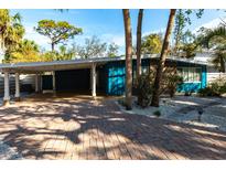 Charming single story home with brick driveway, carport, and lush tropical landscaping at 5239 Winding Way, Sarasota, FL 34242