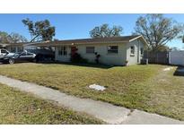 A single-story home features a well-maintained lawn and a red front door at 5124 Brookmeade Dr, Sarasota, FL 34232