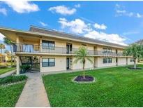 Two-story condo building with mature landscaping and exterior staircases to the second floor units at 12300 Vonn Rd # 7203, Largo, FL 33774