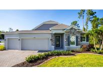 Beautiful single-story home featuring stone accents, manicured landscaping, and a spacious three-car garage at 25172 Calusa Dr, Punta Gorda, FL 33955