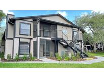 Inviting two-story condo featuring a screened patio and staircase access, offering a blend of comfort and outdoor enjoyment at 4034 Dream Oak Pl # 104, Tampa, FL 33613
