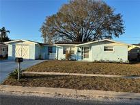 Charming, light blue single-story home with a well-maintained lawn and a white garage in a residential neighborhood at 5125 Janice Ln, Holiday, FL 34690