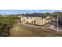 Inviting townhouse showcasing a bright yellow facade and well-manicured landscaping for a warm, welcoming curb appeal at 10759 Keys Gate Dr, Riverview, FL 33579