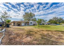 Charming single-story home featuring a spacious front yard under a blue sky with scattered clouds at 5350 47Th N Ave, St Petersburg, FL 33709