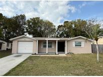 Charming single-story home with a front lawn, attached garage, and covered entryway supported by columns at 4325 Newbury Dr, New Port Richey, FL 34652