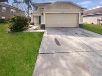 Inviting two-story home showcasing a two-car garage, lush lawn, and well-maintained landscaping at 12549 Chenwood Ave, Hudson, FL 34669