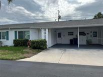 Well-maintained home featuring white exterior with a covered carport and neatly manicured landscaping at 6050 Coral Way # 4, Bradenton, FL 34207