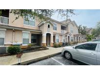 Two-story condo building with sidewalks, parking, and mature landscaping at 10519 Villa View Cir # 10519, Tampa, FL 33647