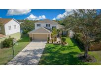 Two-story house with tan garage door, landscaping, and driveway at 221 111 E St, Bradenton, FL 34212