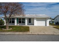 White single story home with teal shutters, attached garage, and landscaped lawn at 9205 40Th N Way # 5, Pinellas Park, FL 33782