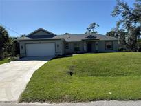 Charming single-story home with a well-manicured lawn and an attached two-car garage at 1449 Marjorie Ln, North Port, FL 34286