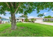 Single-story home with a lush lawn and mature trees at 403 13Th Sw St, Ruskin, FL 33570