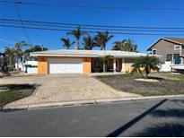 Single-story home with a white garage door and a brick driveway at 1371 Sea Gull S Dr, St Petersburg, FL 33707