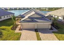 Two-story house with lake view, two-car garage, and landscaped yard at 18053 Cherished Loop, Bradenton, FL 34211