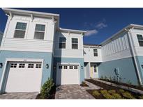 Two-story townhome with white garage doors and light blue exterior at 310 Via Anina Dr, Sarasota, FL 34243