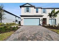 Two-story townhome with light-blue garage door and landscaped front yard at 5426 Tripoli Dr, Palmetto, FL 34221