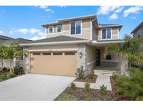 Two-story house with beige exterior, stone accents, and a two-car garage at 5923 Jensen View Ave, Apollo Beach, FL 33572