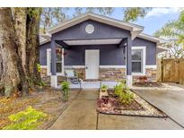 Cute gray house with stone accents, covered porch, and well-manicured landscaping at 1313 Louisiana St, Plant City, FL 33563