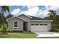 Single-story home with gray exterior, two-car garage, and landscaping at 9049 Players Dr, Weeki Wachee, FL 34613