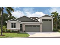 New home exterior with two-car garage and attractive landscaping at 9093 Players Dr, Weeki Wachee, FL 34613