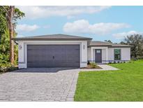 Newly constructed home with gray garage door and paver driveway at 13208 Foresman Blvd, Port Charlotte, FL 33981