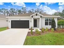 New construction home with a two-car garage and landscaped front yard at 2411 Orange Harvest Pl, Seffner, FL 33584