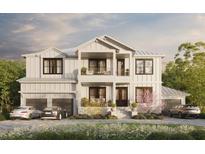 Two-story white farmhouse with a two-car garage and landscaping at 567 Luzon Ave, Tampa, FL 33606