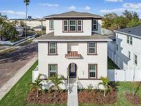 Two-story house with white siding, brown accents, and a walkway at 1939 W Arch St, Tampa, FL 33607