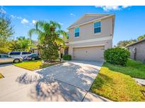 Two-story house with a two-car garage and landscaped front yard at 17035 Peaceful Valley Dr, Wimauma, FL 33598