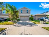 Two-story house with attached garage and landscaped front yard at 17035 Peaceful Valley Dr, Wimauma, FL 33598