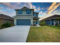 Two-story house with gray siding, blue door, and attached garage at 16111 69Th E Ln, Parrish, FL 34219