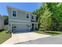 Two-story house with light blue exterior, two-car garage, and landscaping at 7516 Cypress Walk Dr, New Port Richey, FL 34655