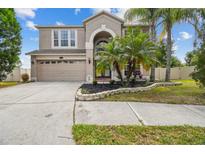 Two story house with a landscaped yard and attached garage at 20233 Still Wind Dr, Tampa, FL 33647