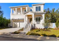Two-story white house with a gray roof, and a landscaped yard at 3011 W Asbury Pl, Tampa, FL 33611