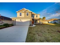 Two-story house with a gray exterior, white garage door, and a landscaped lawn at 16134 69Th Lane East, Parrish, FL 34219