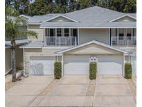 Tan three-unit building with attached garages and balconies at 1817 Hammocks Ave # 1817, Lutz, FL 33549