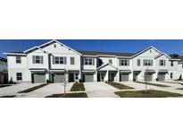 View of new light blue townhomes with gray shutters, gray garage doors, and newly planted grass and trees at 11744 Blackbrook Ct, Seffner, FL 33584