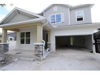 Two-story home with gray siding, stone accents, and a two-car garage at 3221 20Th N St, St Petersburg, FL 33713