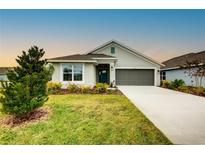 One-story house with gray siding, teal door, and a two-car garage at 7030 162Nd E Pl, Parrish, FL 34219