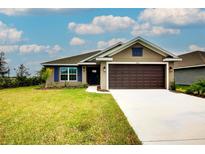 House exterior featuring a two-car garage and landscaped lawn at 7014 162Nd Place E. E Pl, Parrish, FL 34219
