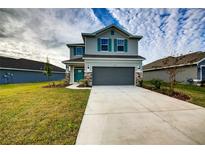 Two-story house with gray siding, teal front door, and attached garage at 16123 69Th E Ln, Parrish, FL 34219