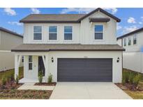 Two-story house with gray garage door and white accents at 1185 Kistna Dr, Zephyrhills, FL 33540