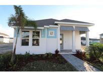 One-story home with light blue and white exterior, landscaped yard, and walkway at 7316 Donnybrook Ln, Sarasota, FL 34240