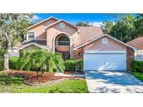 Two-story home with a brick facade, attached garage, and landscaped lawn at 9083 Quail Creek Dr, Tampa, FL 33647