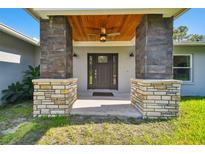 Inviting front entrance with stone columns and wood ceiling at 28628 Bennington Dr, Wesley Chapel, FL 33544