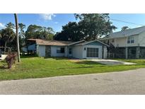 Cozy single-story home featuring a screen garage, and a well-maintained lawn at 6138 Island Dr, Weeki Wachee, FL 34607
