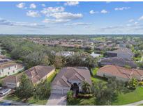 Aerial view of a residential neighborhood with lush landscaping and lake views at 5621 Rock Dove Dr, Sarasota, FL 34241