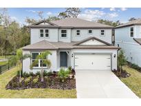 Two-story house with gray siding, white garage door, and landscaping at 12614 Glenn Creek Dr, Riverview, FL 33569
